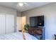 Neutral-toned bedroom with closet and a dresser with TV at 7175 Steubling Glen St, North Las Vegas, NV 89084
