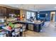 Open-concept kitchen featuring dark cabinetry, granite countertops, stainless steel appliances, and a kitchen island at 7175 Steubling Glen St, North Las Vegas, NV 89084