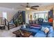 Open-concept living room featuring modern staircase, tile floors, and a comfortable blue sofa at 7175 Steubling Glen St, North Las Vegas, NV 89084