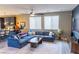 Open-concept living room featuring a large sectional sofa, stylish decor, and an adjacent kitchen area at 7175 Steubling Glen St, North Las Vegas, NV 89084