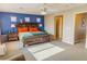 Main bedroom with a large window, wooden furniture and a bright blue accent wall at 7175 Steubling Glen St, North Las Vegas, NV 89084