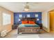 Main bedroom with a bright blue accent wall, carpet flooring, and ample natural light at 7175 Steubling Glen St, North Las Vegas, NV 89084