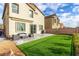 Inviting backyard featuring a manicured lawn, patio seating area, and privacy fence ideal for outdoor living at 7733 Rosebark Cliffs St, North Las Vegas, NV 89084