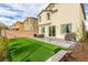 Well-maintained backyard with artificial turf, a patio, and a block wall at 7733 Rosebark Cliffs St, North Las Vegas, NV 89084