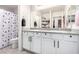 Bathroom boasting double sinks, granite counters, white cabinets, and a shower with a polka-dot curtain at 7733 Rosebark Cliffs St, North Las Vegas, NV 89084