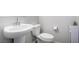 Clean half-bathroom featuring a pedestal sink and toilet with neutral wall paint at 7733 Rosebark Cliffs St, North Las Vegas, NV 89084