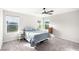 Bright bedroom with plush carpet, natural light from three windows, and ceiling fan at 7733 Rosebark Cliffs St, North Las Vegas, NV 89084
