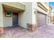Home exterior showing a stone-accented facade, a covered entryway, and a brown two-car garage door at 7733 Rosebark Cliffs St, North Las Vegas, NV 89084