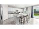 Bright kitchen with white cabinets, stainless steel appliances, and an island with barstool seating and backyard view at 7733 Rosebark Cliffs St, North Las Vegas, NV 89084