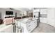 Modern kitchen island with granite countertops and stainless steel appliances adjacent to open concept living area at 7733 Rosebark Cliffs St, North Las Vegas, NV 89084
