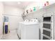 Convenient laundry room with a washer, dryer, and upper shelving for storage at 7733 Rosebark Cliffs St, North Las Vegas, NV 89084