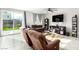 Spacious living room featuring neutral paint, a ceiling fan, large sliding doors and multiple couches at 7733 Rosebark Cliffs St, North Las Vegas, NV 89084
