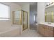 Bathroom featuring a soaking tub, glass shower and light wood vanity at 787 Craigmark Ct, Henderson, NV 89002
