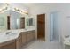 Bright bathroom with double sinks, large mirror, and walk-in closet at 787 Craigmark Ct, Henderson, NV 89002