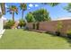 Backyard featuring artificial grass, palms, and a brick perimeter wall at 8232 Silver Vine St, North Las Vegas, NV 89085