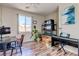 Spacious bedroom with laminate floors, a large window with mountain views, and a home office setup at 8232 Silver Vine St, North Las Vegas, NV 89085