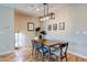 Bright dining area with a modern light fixture, hardwood floors, and neutral wall color creating an inviting space at 8232 Silver Vine St, North Las Vegas, NV 89085