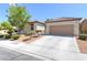 Inviting single-story home featuring desert landscaping, a tile roof, and an attached two-car garage at 8232 Silver Vine St, North Las Vegas, NV 89085