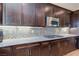 Modern kitchen features granite countertops, tile backsplash, and stainless steel microwave and gas range at 8232 Silver Vine St, North Las Vegas, NV 89085