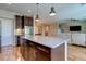 Open kitchen with an island offering bar seating, seamlessly connecting to the living and dining areas at 8232 Silver Vine St, North Las Vegas, NV 89085