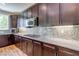 Well-appointed kitchen with granite countertops, stainless steel appliances, and dark wood cabinets at 8232 Silver Vine St, North Las Vegas, NV 89085
