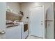 The laundry room has a washer, dryer, storage shelves, and a stainless steel refrigerator at 8232 Silver Vine St, North Las Vegas, NV 89085