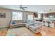 Spacious living room with a large sectional sofa, bright windows, and hardwood flooring leading to kitchen at 8232 Silver Vine St, North Las Vegas, NV 89085