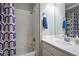 Bright bathroom featuring a shower and tub combo, single sink vanity and blue decorative design at 8504 W Gilmore Ave, Las Vegas, NV 89129