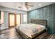Bedroom with wood-look floors, ceiling fan, decorative tiled accent wall, and French doors at 8504 W Gilmore Ave, Las Vegas, NV 89129