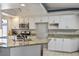Bright kitchen featuring granite countertops, white cabinets, and stainless steel appliances and updated fixtures at 8504 W Gilmore Ave, Las Vegas, NV 89129