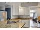 Kitchen featuring granite countertops, white cabinets, stainless steel appliances, and a view to the living room at 8504 W Gilmore Ave, Las Vegas, NV 89129