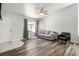 Comfortable living room with hardwood floors, a ceiling fan, and natural light through a window with curtains at 8504 W Gilmore Ave, Las Vegas, NV 89129