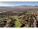 Overhead shot of a golf course community with a pond and mountain backdrop at 9000 Opus Dr, Las Vegas, NV 89117