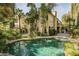 This home features a backyard with a sparkling pool, lush landscaping, and an expansive patio at 9000 Opus Dr, Las Vegas, NV 89117