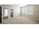 An empty carpeted room with neutral walls features an open closet and large window for natural light at 9000 Opus Dr, Las Vegas, NV 89117