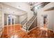 Grand foyer with a sweeping staircase, hardwood floors, and elegant lighting at 9000 Opus Dr, Las Vegas, NV 89117
