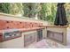 Outdoor kitchen featuring a built-in grill, sink, and stainless steel storage at 9000 Opus Dr, Las Vegas, NV 89117