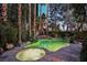The backyard offers a uniquely shaped pool with a spa surrounded by mature trees and bushes at 9000 Opus Dr, Las Vegas, NV 89117