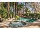 Serene backyard oasis with a sparkling pool, hot tub, and lush, mature landscaping at 9000 Opus Dr, Las Vegas, NV 89117