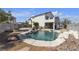 An inviting backyard showcasing a sparkling pool with rock features and desert landscaping at 9290 S Cool Creek Ave, Las Vegas, NV 89147