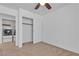 Carpeted bedroom featuring ceiling fan, laundry area with closet and modern appliances at 9290 S Cool Creek Ave, Las Vegas, NV 89147