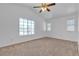 Bright bedroom with large windows, a ceiling fan, and neutral carpet at 9290 S Cool Creek Ave, Las Vegas, NV 89147
