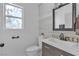 Charming half bathroom features a modern vanity, decorative mirror, and stylish wood paneling at 9290 S Cool Creek Ave, Las Vegas, NV 89147