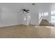 Open concept living area with tile flooring, ceiling fan, and staircase leading to the upper level at 9290 S Cool Creek Ave, Las Vegas, NV 89147