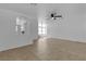 Spacious living area with tile flooring, arched feature, ceiling fan, and staircase leading to the upper level at 9290 S Cool Creek Ave, Las Vegas, NV 89147
