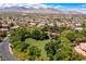 An aerial shot shows the neighborhood featuring community park, tennis courts, and mountain views at 9501 Balatta Canyon Ct, Las Vegas, NV 89144