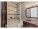 Charming bathroom featuring a tiled shower, tiled walls and vanity with dark wood cabinets at 9501 Balatta Canyon Ct, Las Vegas, NV 89144