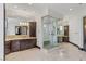 Bright bathroom with marble floors, dark wood cabinets and glass enclosed walk-in shower at 9501 Balatta Canyon Ct, Las Vegas, NV 89144