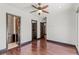 Spacious bedroom featuring wood floors, modern ceiling fan and entrances to a closet and bathroom at 9501 Balatta Canyon Ct, Las Vegas, NV 89144