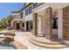 Luxury home exterior featuring a large patio space with stone columns and a built-in grill at 9501 Balatta Canyon Ct, Las Vegas, NV 89144